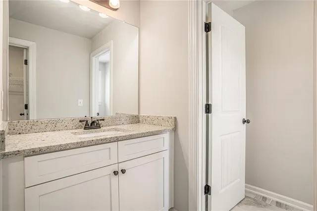 a bathroom with a granite countertop sink a toilet and shower