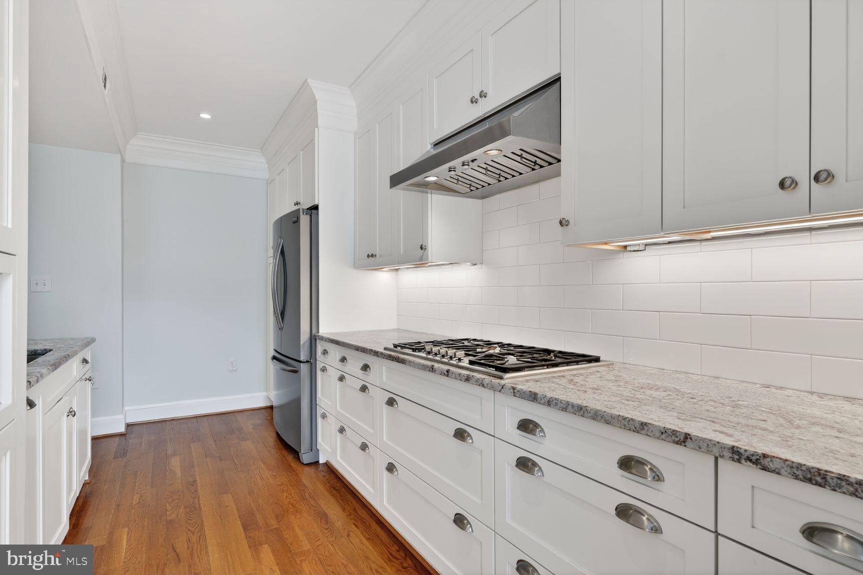1616 44th Street Northwest Washington, DC 20007 - Photo 11 of 51 a kitchen with granite countertop a stove and a wooden floor