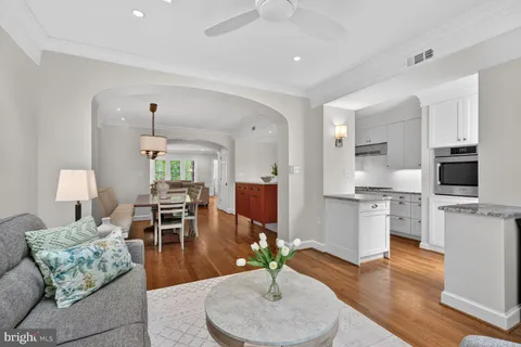 a living room with furniture kitchen view and a wooden floor