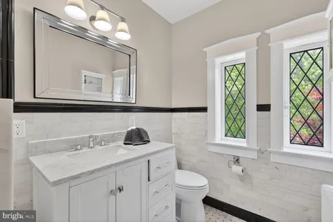 a bathroom with a sink a toilet and a mirror