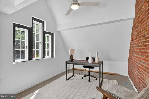 a view of a workspace with furniture and a window