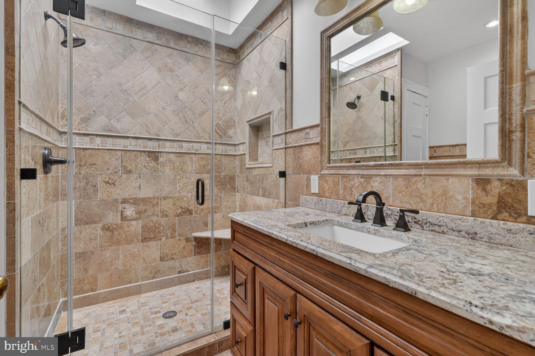 1616 44th Street Northwest Washington, DC 20007 - Photo 27 of 51 a bathroom with a granite countertop sink a mirror and shower