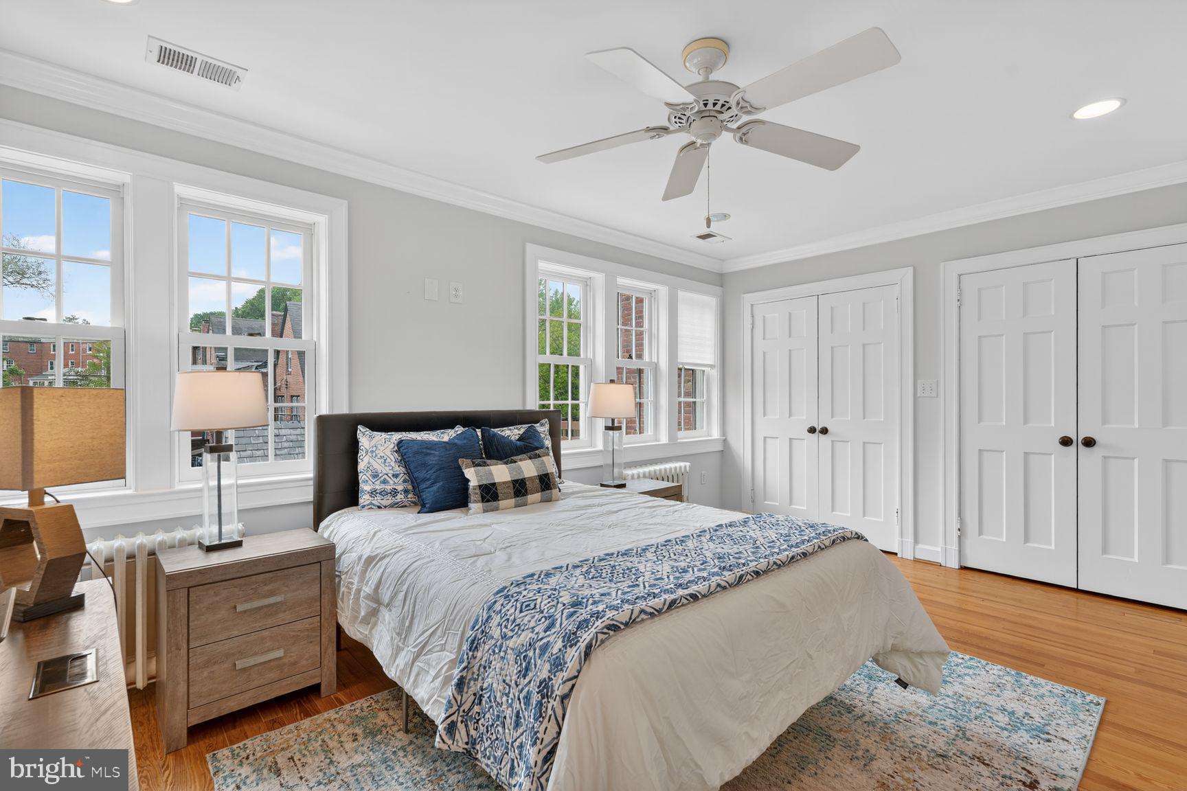 1616 44th Street Northwest Washington, DC 20007 - Photo 28 of 51 a spacious bedroom with a large bed a chandelier and windows