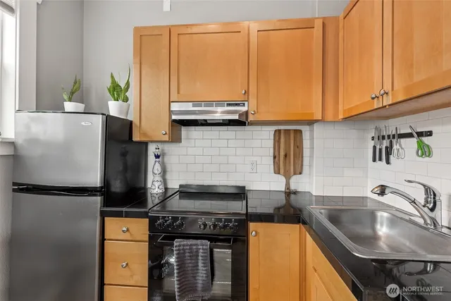 a kitchen with stainless steel appliances granite countertop a sink stove and refrigerator