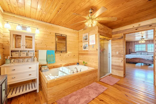 a bathroom with a tub sink and mirror