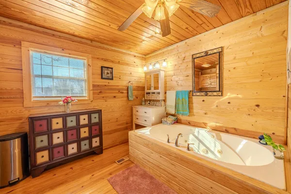 a bathroom with a tub sink and mirror
