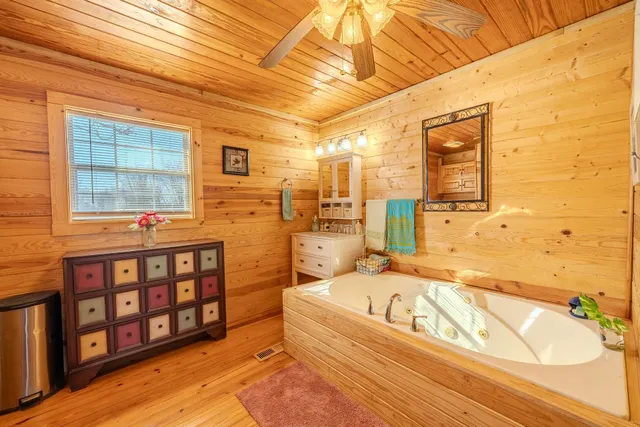 a bathroom with a tub sink and mirror
