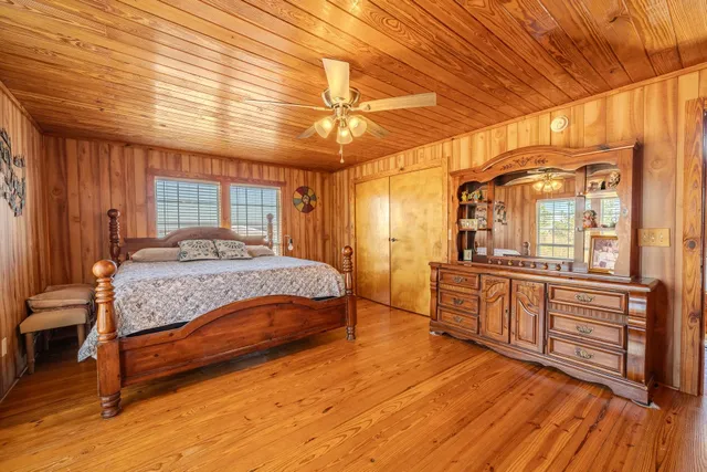 a bedroom with a large bed and wooden floor