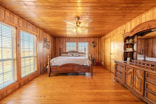 a spacious bedroom with a bed a chandelier and next to a window