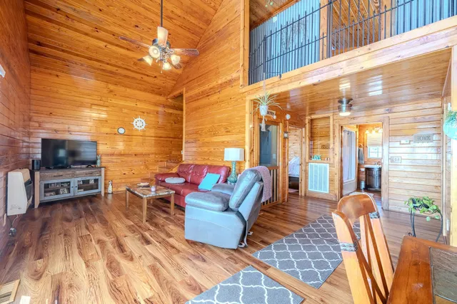 a living room with furniture a flat screen tv and a floor to ceiling window