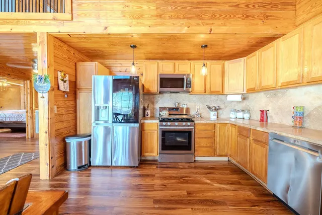 a kitchen with stainless steel appliances granite countertop a stove a sink and a refrigerator