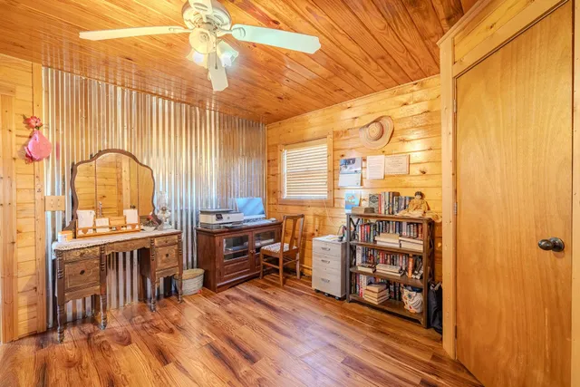 a room with lots of wooden furniture and windows