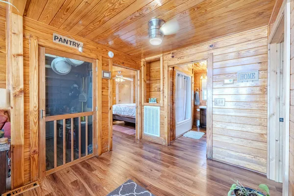 a view of a hallway with wooden floor and windows