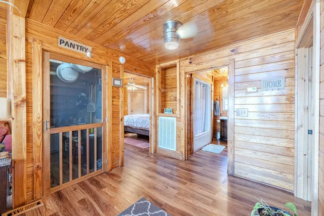 a view of a hallway with wooden floor and windows