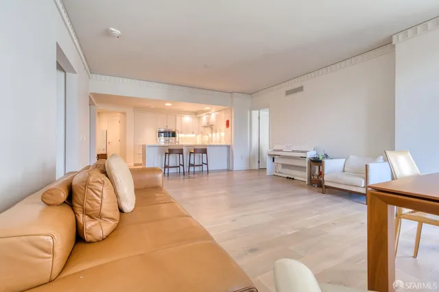 a view of a hallway with wooden floor and a bathroom
