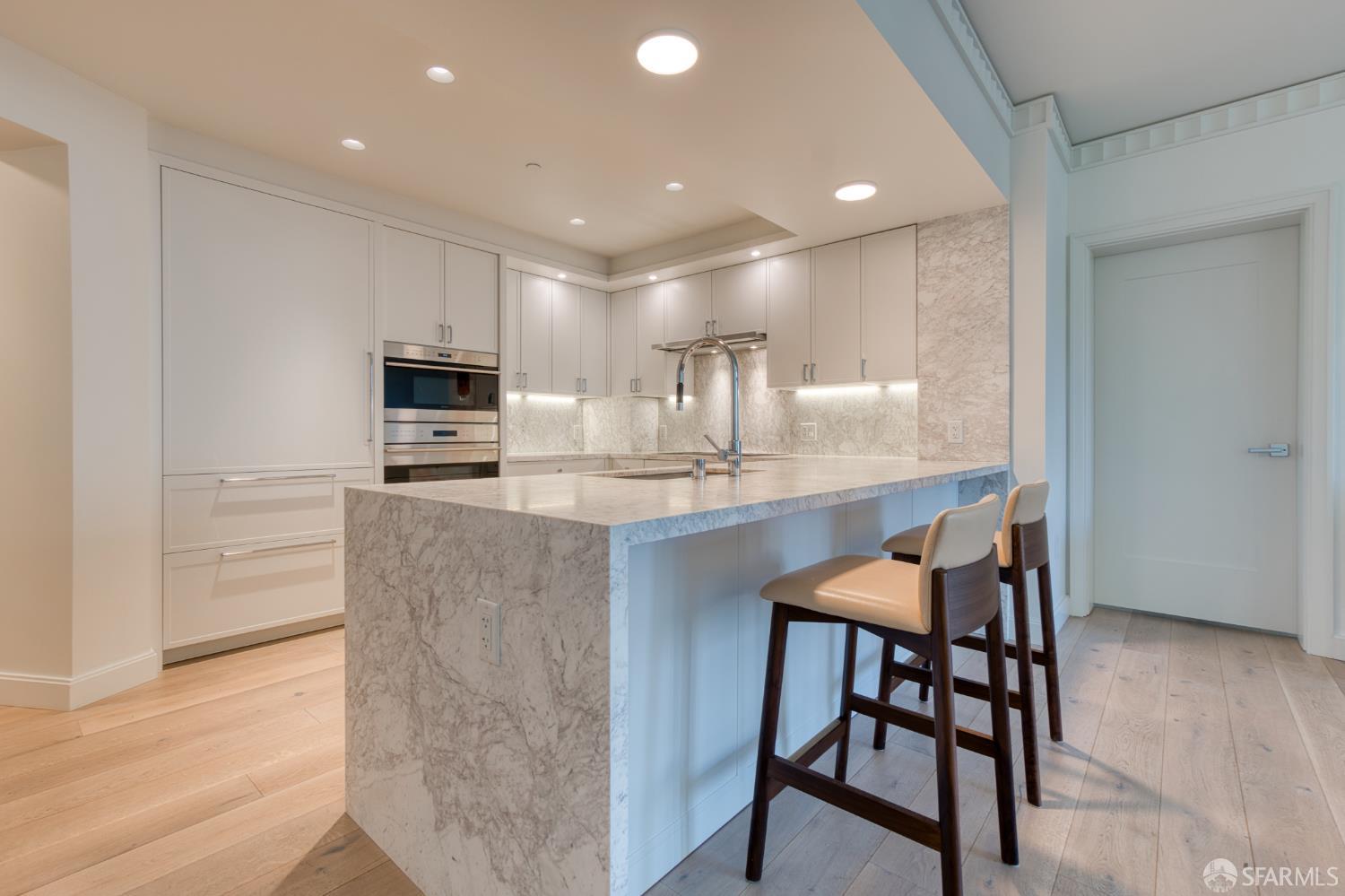 875 California Street, Unit 403 San Francisco, CA 94108 - Photo 36 of 56 a kitchen with kitchen island granite countertop wooden floor cabinets and appliances