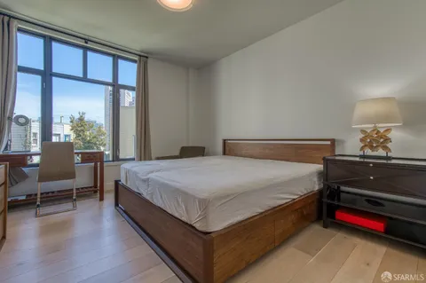 a spacious bedroom with a bed and a dresser