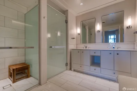 a bathroom with a granite countertop sink a toilet a mirror and shower