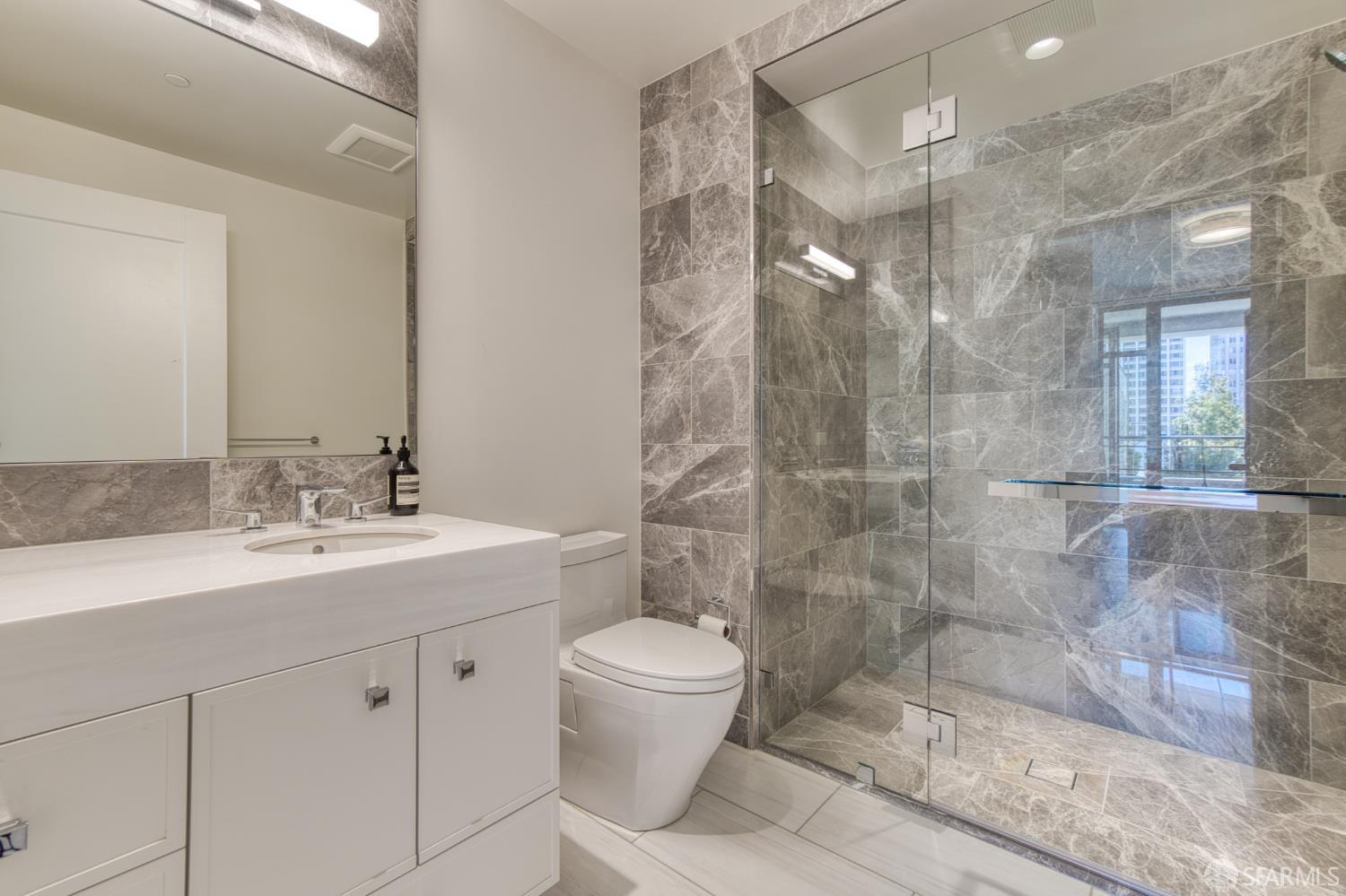 875 California Street, Unit 403 San Francisco, CA 94108 - Photo 50 of 56 a bathroom with a granite countertop sink a toilet a mirror and shower