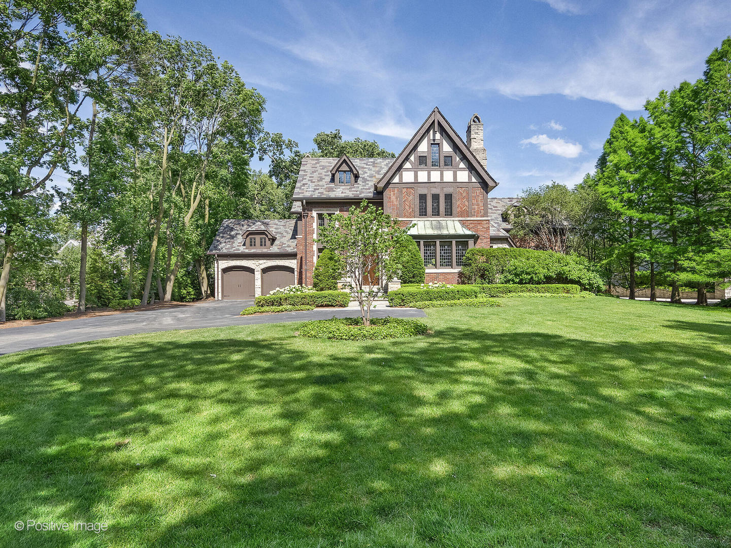 a front view of a house with yard and green space