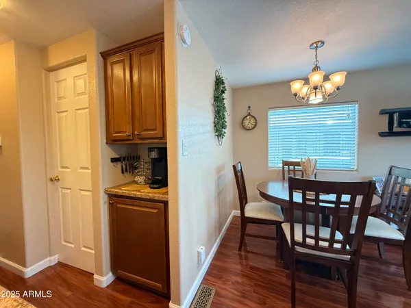 a dining room with wooden floor a chandelier a wooden table and chairs