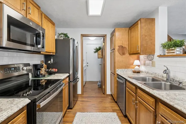 a kitchen with stainless steel appliances granite countertop a sink stove and refrigerator