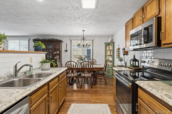 a kitchen with stainless steel appliances granite countertop a sink stove and cabinets