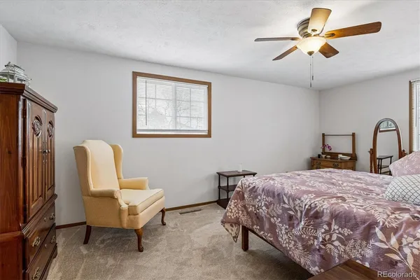 a bedroom with a bed a couch and a chandelier