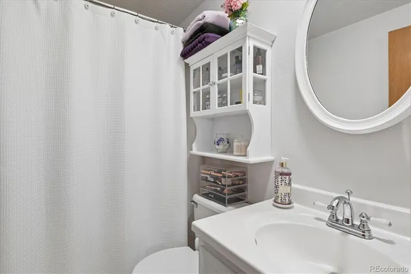 a bathroom with a sink toilet and a mirror