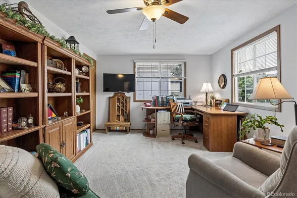 a view of a livingroom with workspace and a window