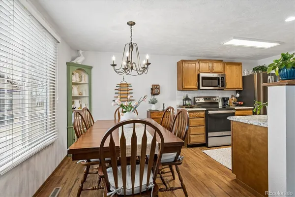a view of a dining room with furniture a chandelier and wooden floor