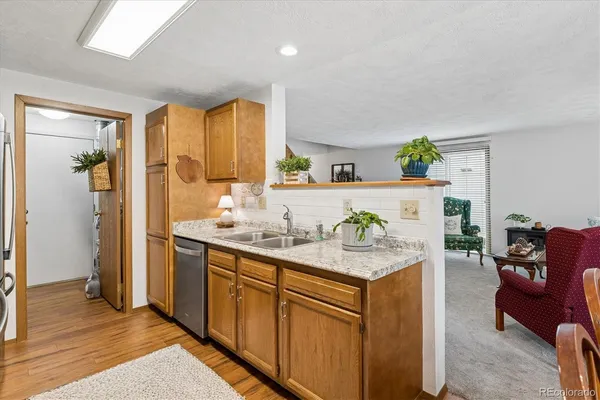 a room with a sink a counter top space and living room view