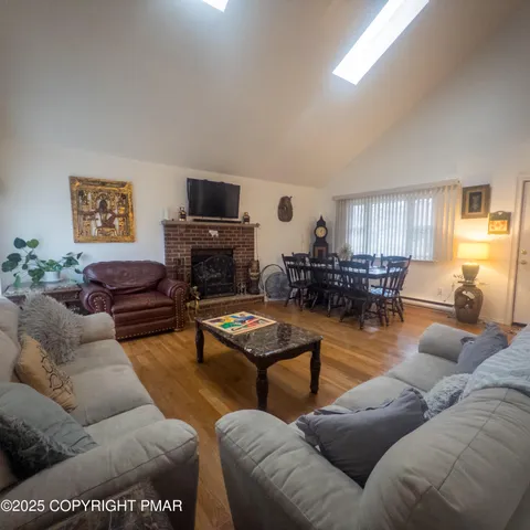 a living room with furniture kitchen view and a window