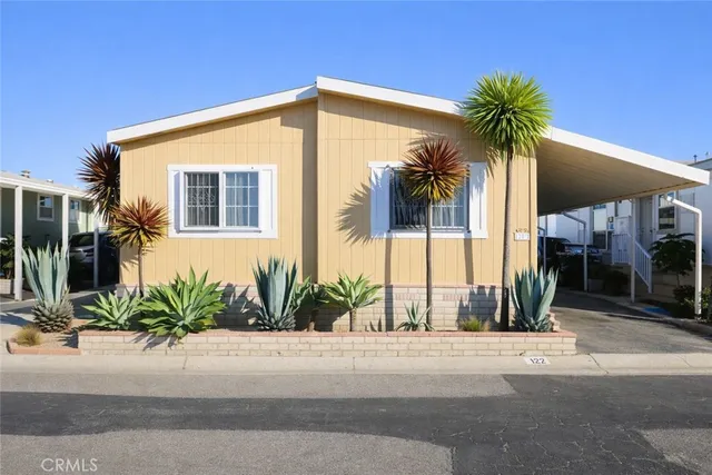 a front view of multiple houses with palm trees