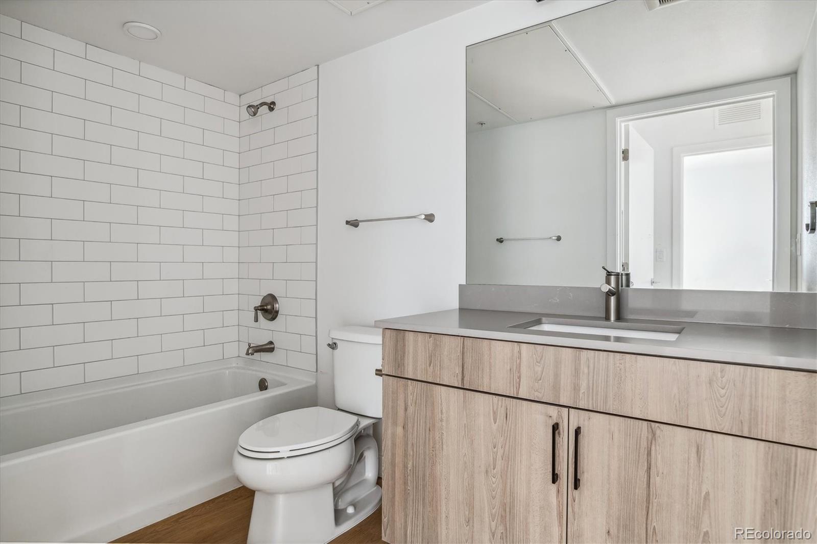 3575 Chestnut Place, Unit 203 Denver, CO 80216 - Photo 8 of 14 a bathroom with a sink a toilet and shower