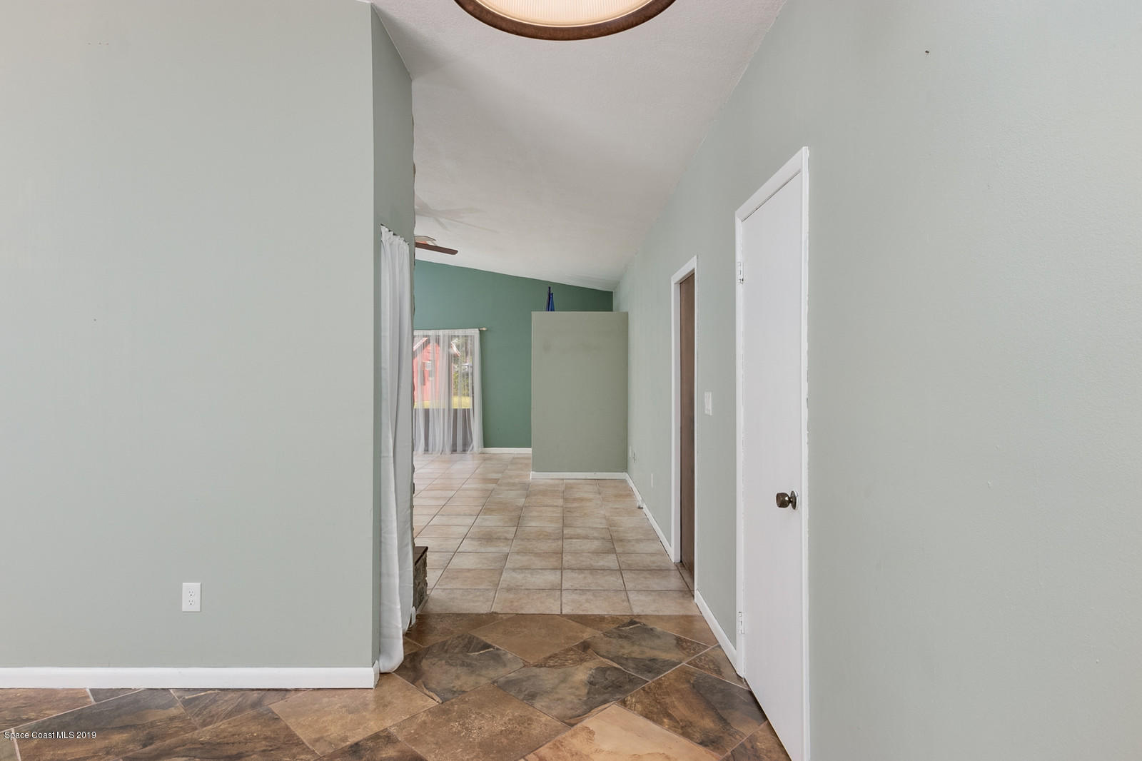 1695 Emmaus Road Northwest Palm Bay, FL 32907 - Photo 14 of 30 a view of a hallway with wooden floor and a bathroom