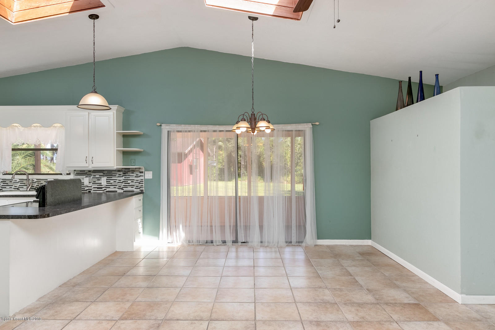 1695 Emmaus Road Northwest Palm Bay, FL 32907 - Photo 17 of 30 a kitchen with kitchen island a stove a sink and a refrigerator