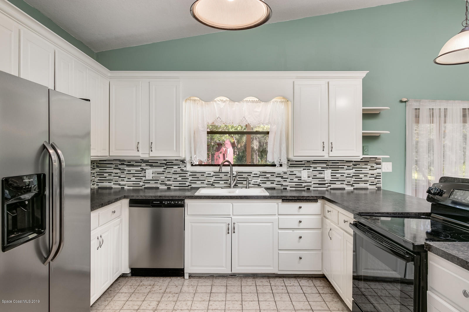 1695 Emmaus Road Northwest Palm Bay, FL 32907 - Photo 18 of 30 a kitchen with white cabinets and appliances