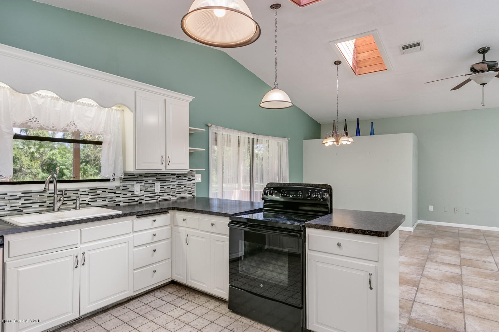 1695 Emmaus Road Northwest Palm Bay, FL 32907 - Photo 19 of 30 a kitchen with a stove cabinets and window