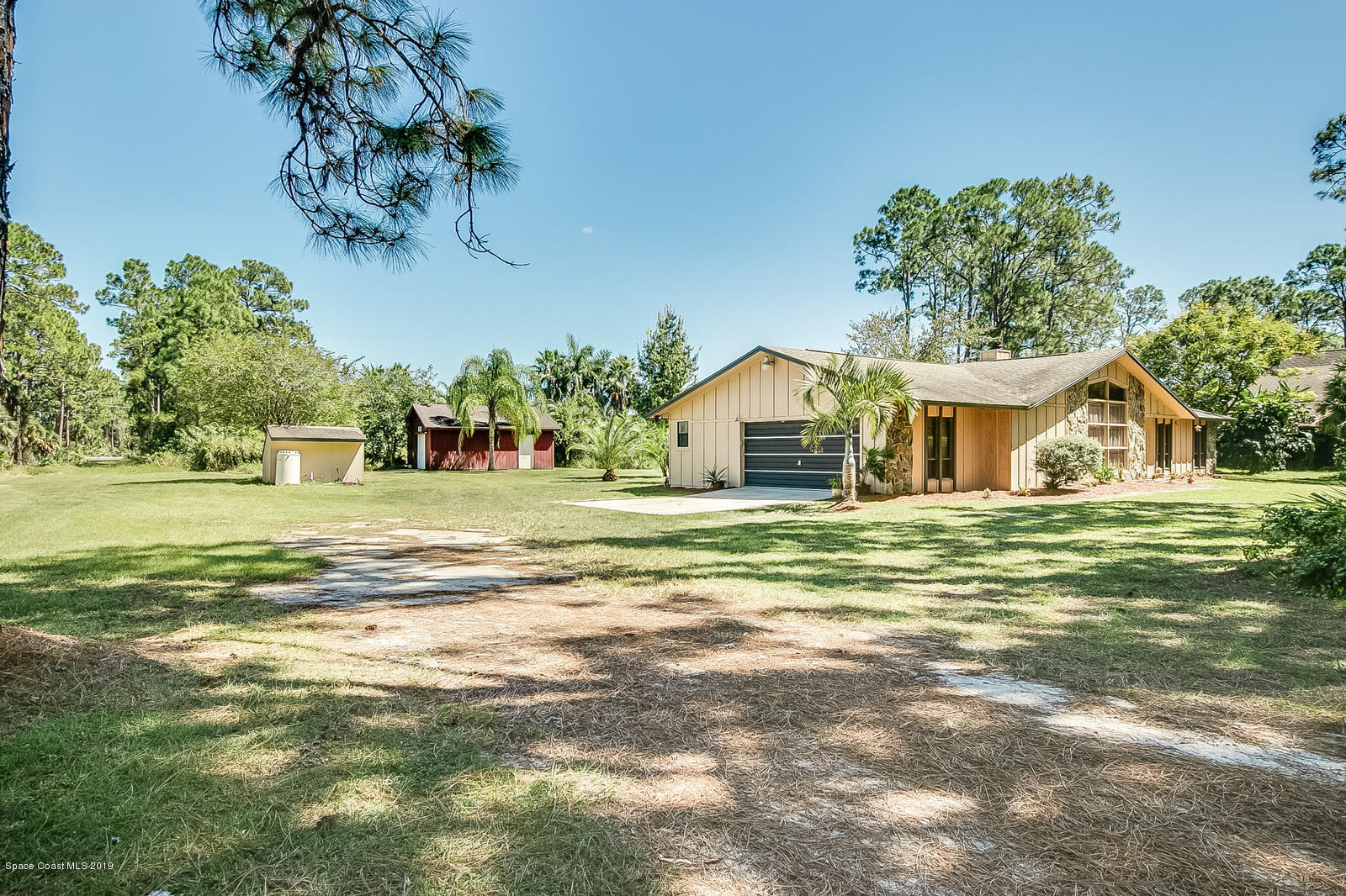 1695 Emmaus Road Northwest Palm Bay, FL 32907 - Photo 26 of 30 a view of house with garden and tall trees