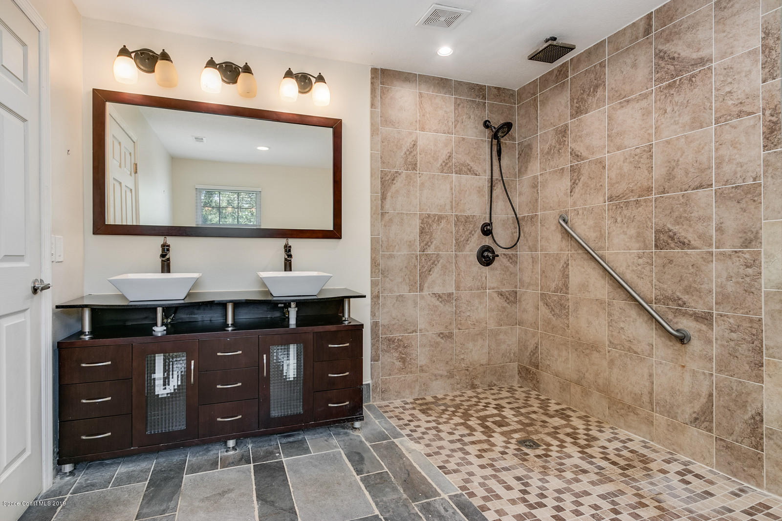 1695 Emmaus Road Northwest Palm Bay, FL 32907 - Photo 7 of 30 a bathroom with a sink vanity and a mirror
