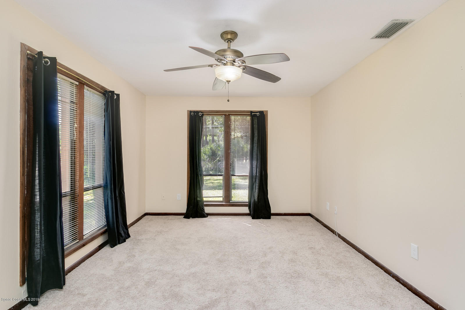 1695 Emmaus Road Northwest Palm Bay, FL 32907 - Photo 9 of 30 an empty room with fan and windows