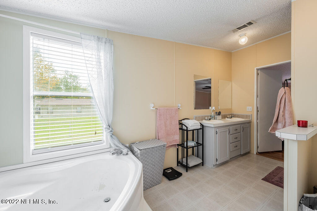 540532 Lem Turner Road Callahan, FL 32011 - Photo 22 of 62 a view of a bathroom with a tub sink and mirror