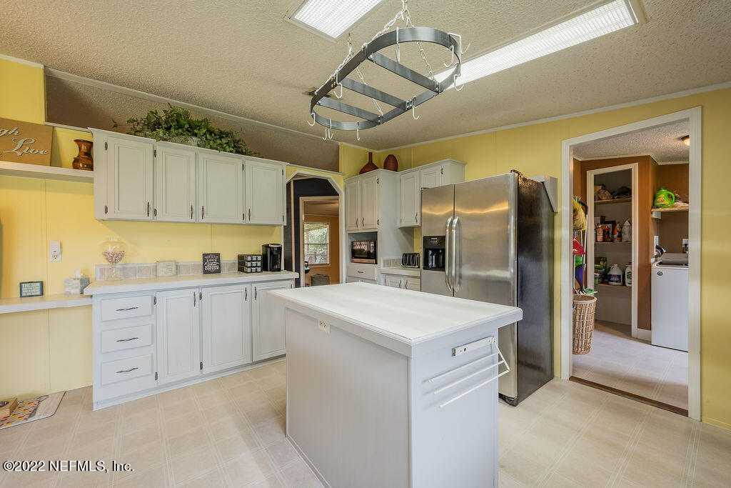 540532 Lem Turner Road Callahan, FL 32011 - Photo 30 of 62 a kitchen with a sink a refrigerator and cabinets