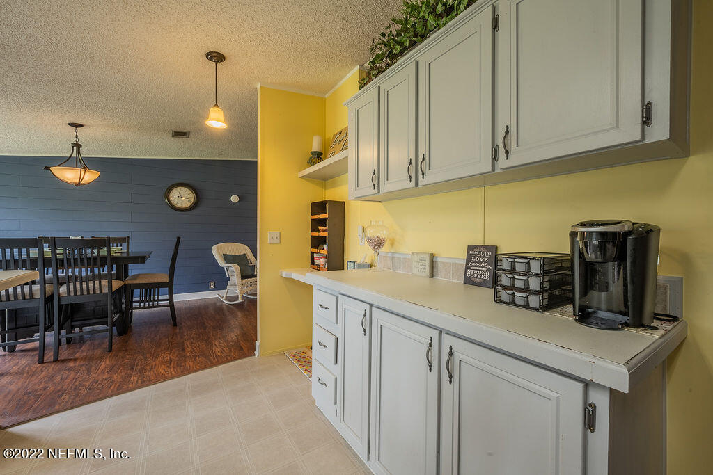 540532 Lem Turner Road Callahan, FL 32011 - Photo 31 of 62 a kitchen with stainless steel appliances granite countertop a sink dishwasher a microwave oven a stove and a dining table with wooden cabinet