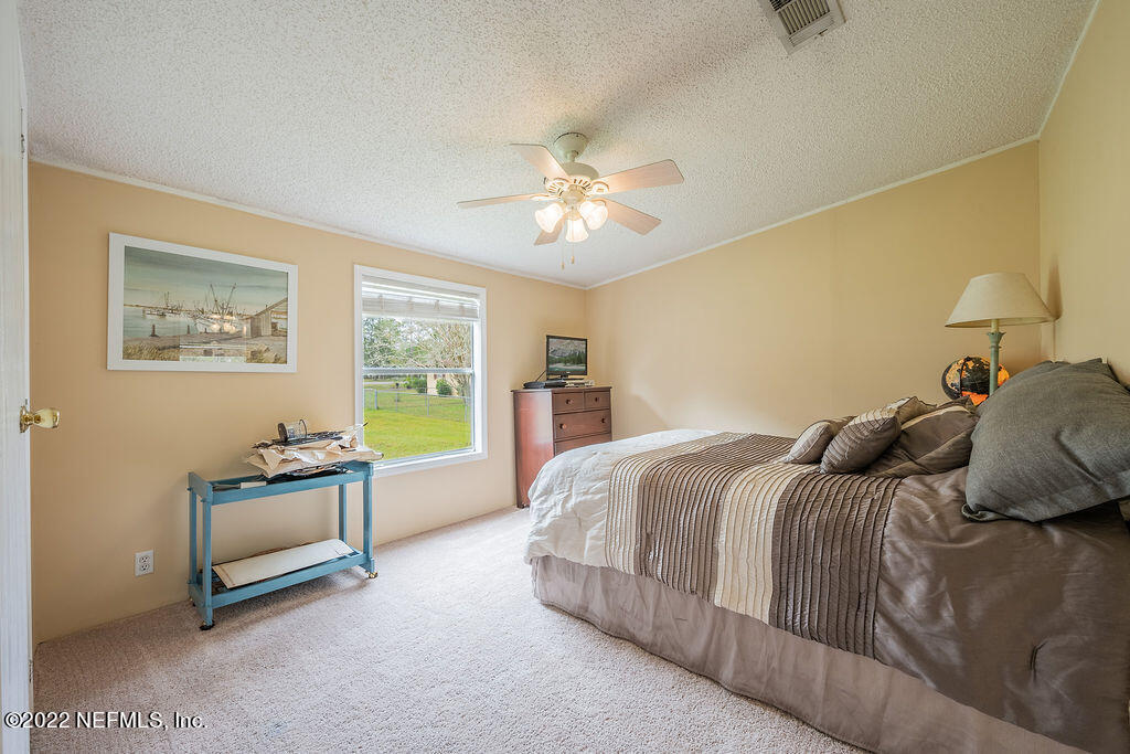 540532 Lem Turner Road Callahan, FL 32011 - Photo 44 of 62 a bedroom with a bed and a chandelier