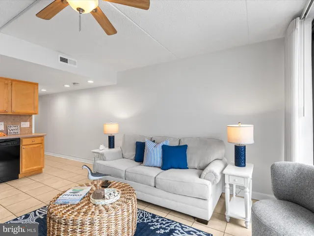 a dining room with furniture a potted plant and wooden floor