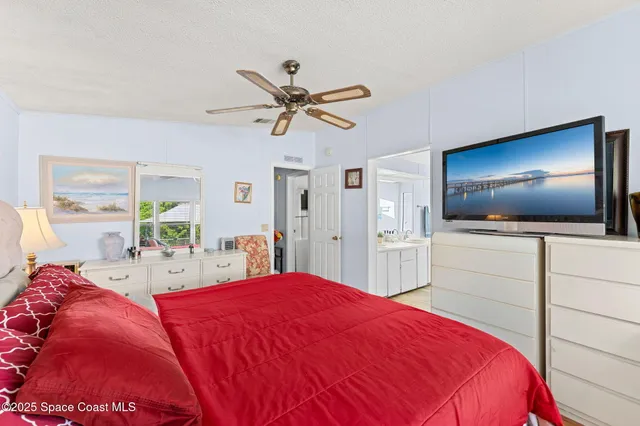a bedroom with a large bed and a flat screen tv