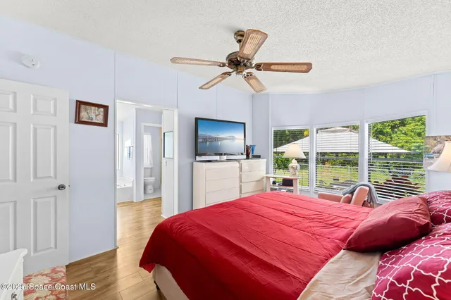 a bedroom with a large bed and a flat tv screen