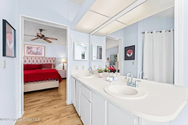 a en suite bathroom with a double vanity sink and a mirror